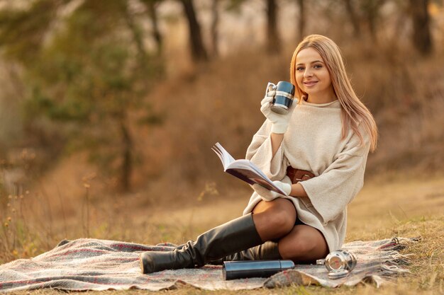 Long shot blonde woman reading a book