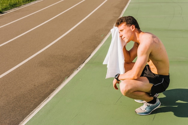 Long shot of body builder wiping off sweat