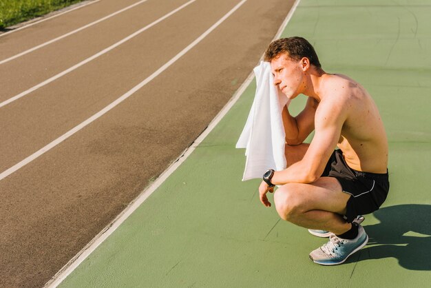 Long shot of body builder wiping off sweat