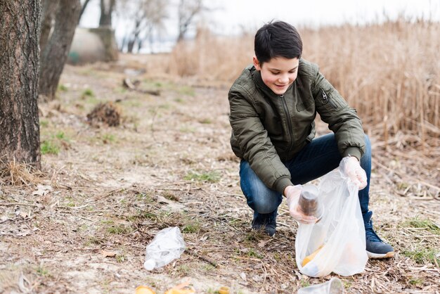 Long shot of boy cleaning the ground