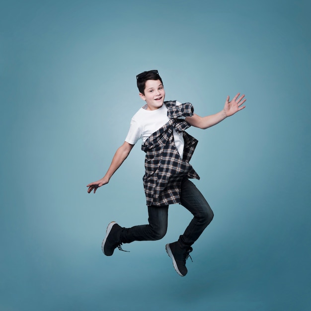 Long shot of boy jumping and posing