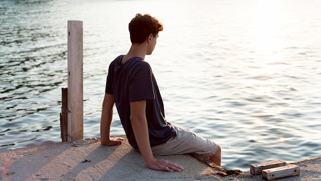 Long shot of boy relaxing at sea