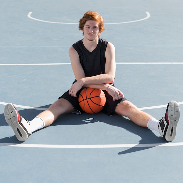 バスケットボールのボールを持つ少年のロングショット