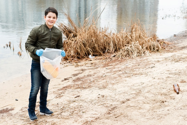 Free photo long shot of boy with plastic bag