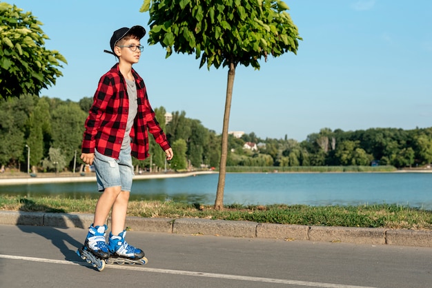 ローラーブレードを持つ少年のロングショット