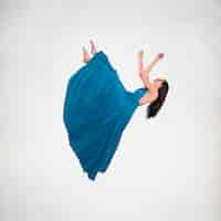 Free photo long shot brunette woman in dress levitating