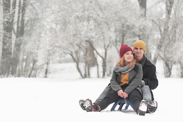 Long shot of couple sitting on sleigh front view