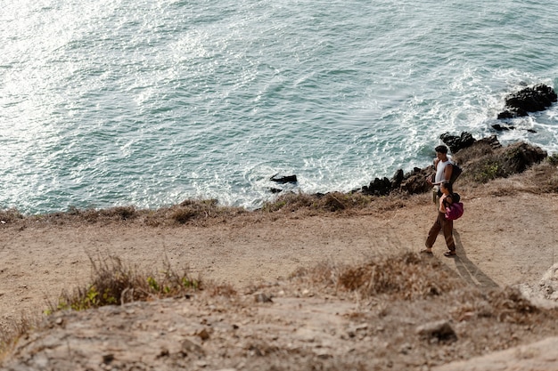 무료 사진 해변에서 걷는 롱 샷 커플