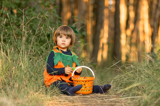 Длинный снимок милого маленького мальчика в костюме тыквы