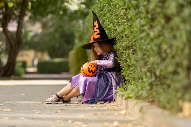 Длинный снимок милой маленькой девочки в костюме ведьмы