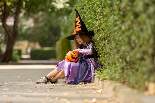 Long shot of cute little girl with witch costume