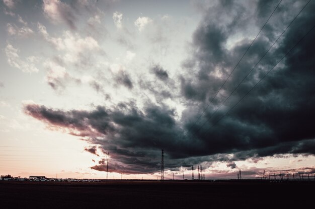 Long shot of a dark cloudy sky above antenna towers