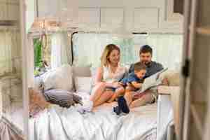 Free photo long shot family looking through a map in a caravan