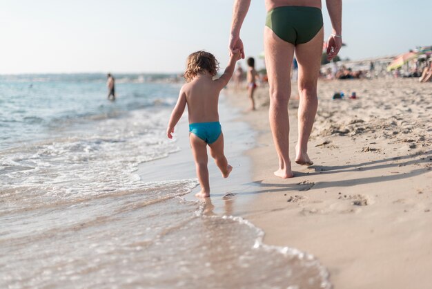 Long shot of father and son walking by the seashore