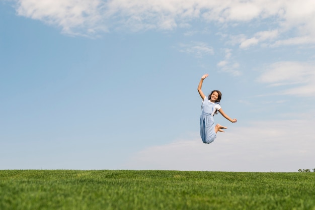 Long shot girl jumping barefoot 