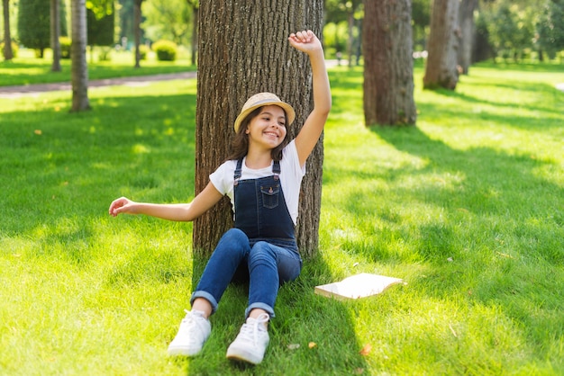 Long shot girl posing in front of a tree