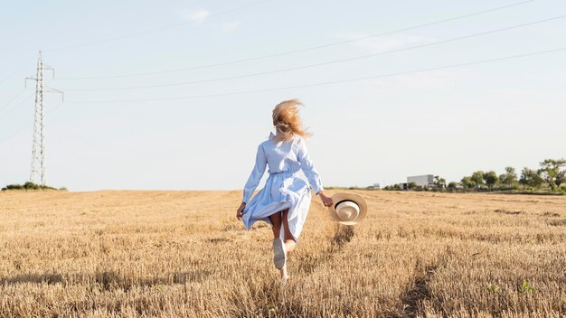 Ragazza del colpo lungo che corre in un campo