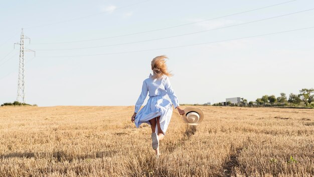 Long shot girl running in a field