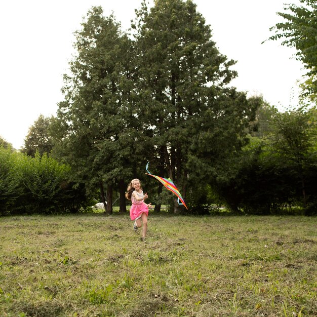 long shot of happy girl having fun with a kite