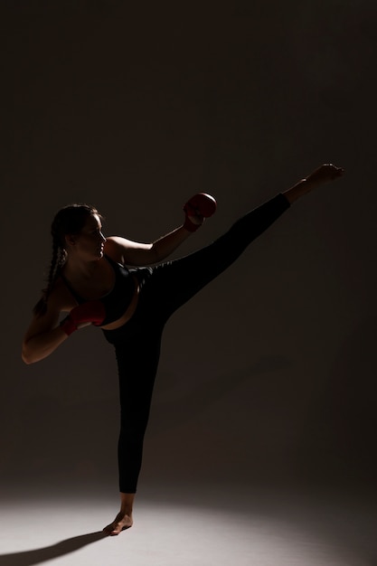 Free photo long shot of karate woman dark background