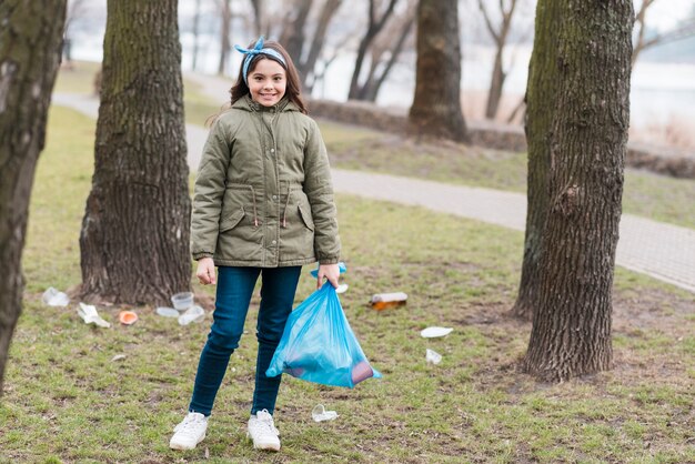 Long shot of little girl with plastic bag