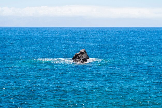 Long shot lone rock in crystalline sea