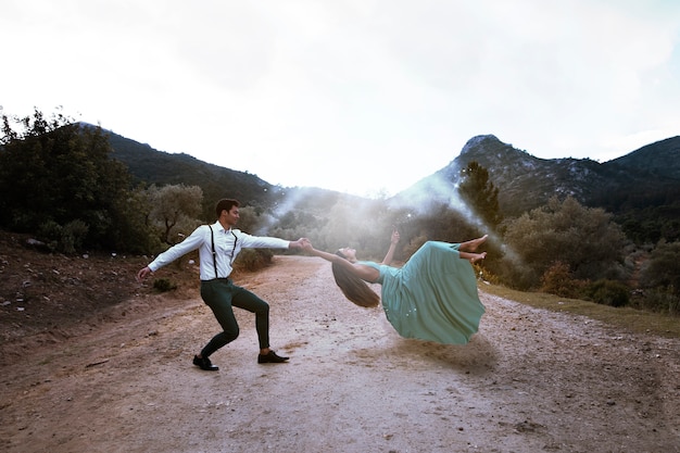 Long shot man holding levitating woman