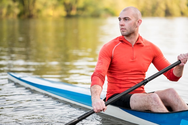 Long shot man holding oar