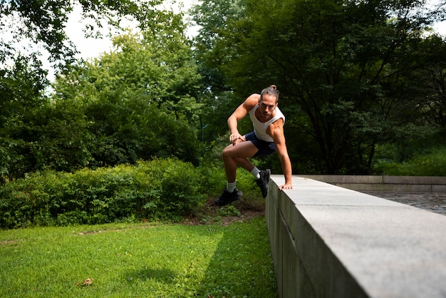 Long shot of man jumping over stone fence