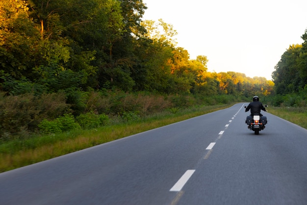 Foto gratuita uomo a tiro lungo in sella a una moto