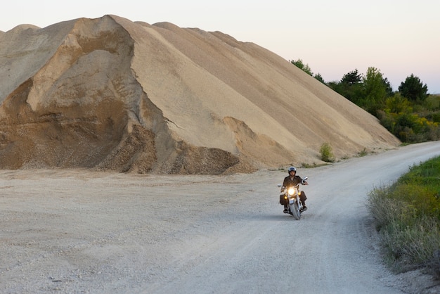 Foto gratuita uomo a tiro lungo in sella a una moto