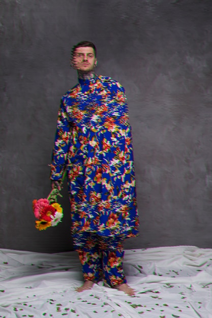 Free photo long shot of man in robe holding flowers