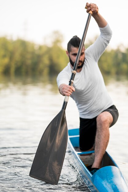 Long shot man rowing with oar
