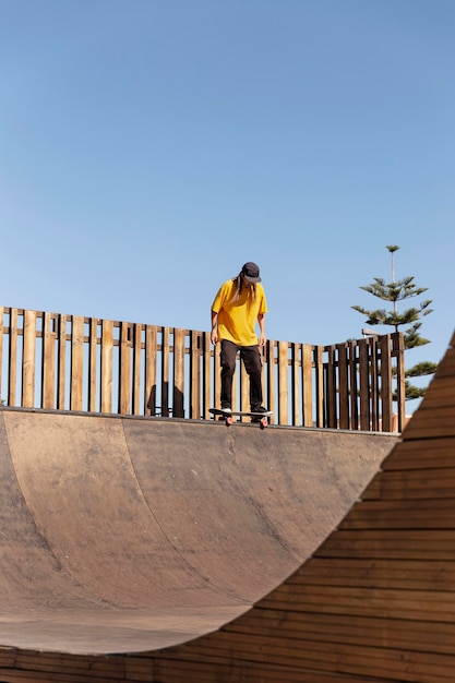 Foto gratuita uomo a tiro lungo su skateboard