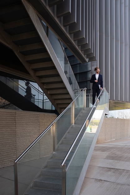 Long shot man in suit walking down stairs