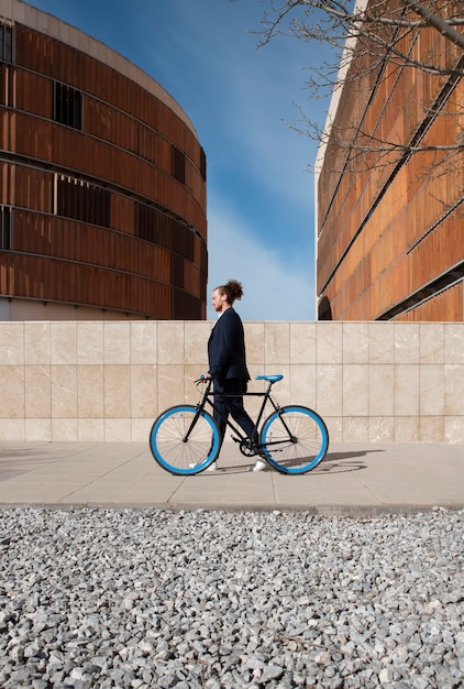 Long shot man with bicycle going to job