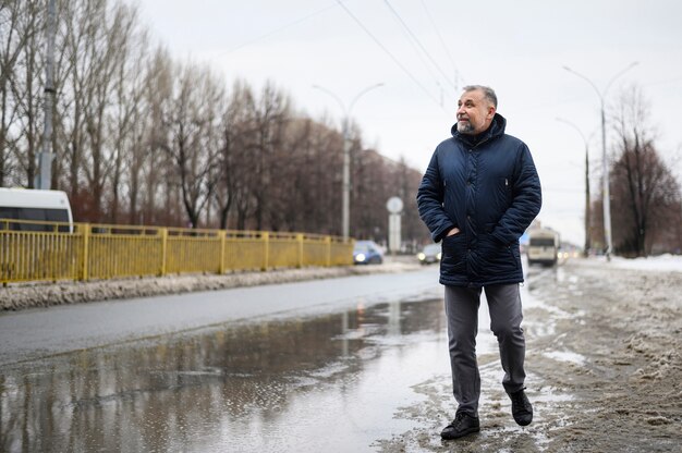 Long shot mature man walking outside