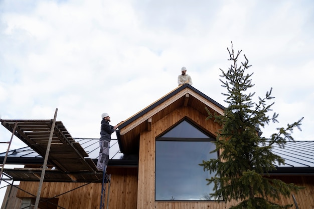 Long shot men working together on roof