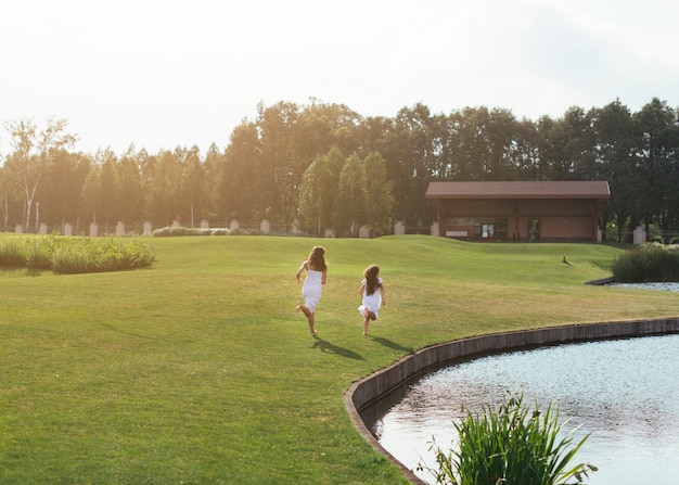 Free photo long shot mother and daughter running outdoors