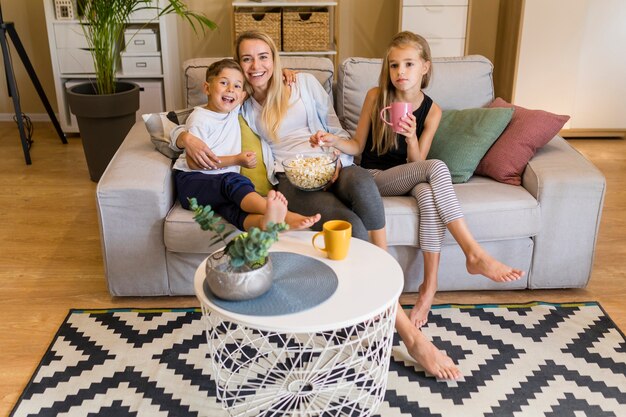 Long shot of mother and her children sitting in living room
