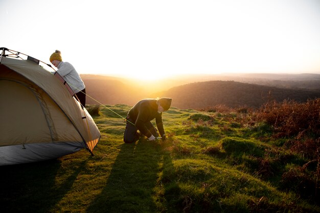 Long shot people setting up tent