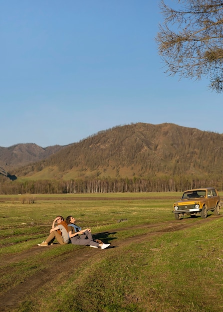 Long shot people sitting on grass together