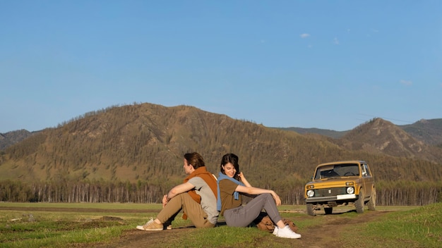 Free photo long shot people sitting on grass