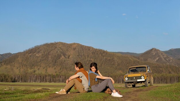 Long shot people sitting on grass