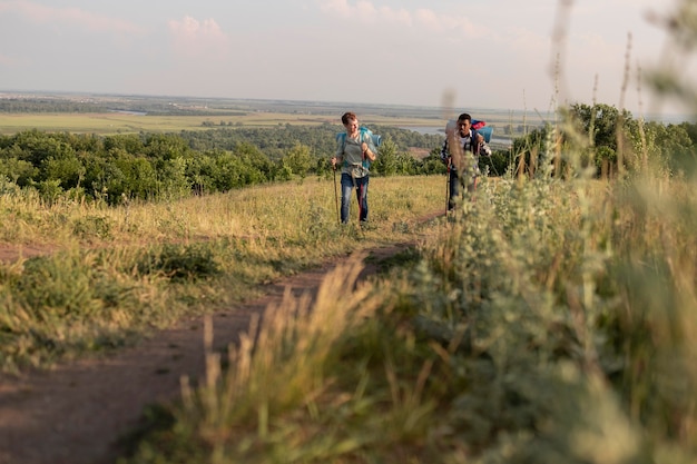 Бесплатное фото Длинные выстрелы людей, идущих с рюкзаками