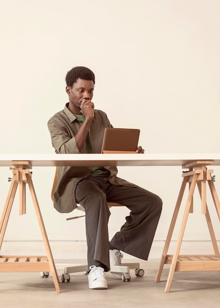 Long shot of person sitting and working on laptop