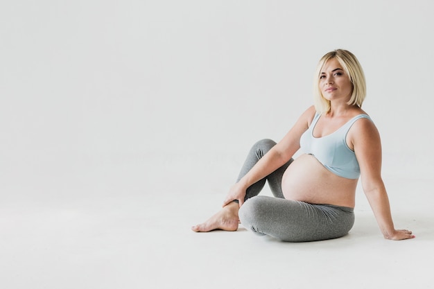 Long shot pregnant woman looking at camera