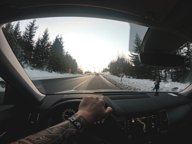 Long shot of a road cleared of snow. Captured from inside a car