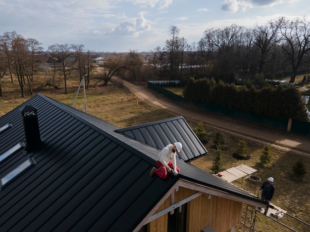 Foto gratuita roofer a tiro lungo che lavora con il casco