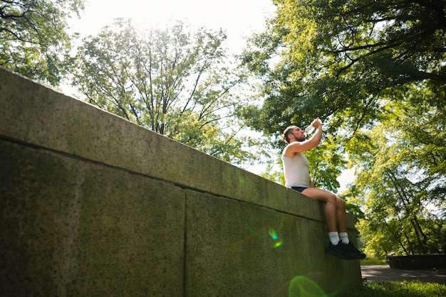 Free photo long shot of runner drinking water